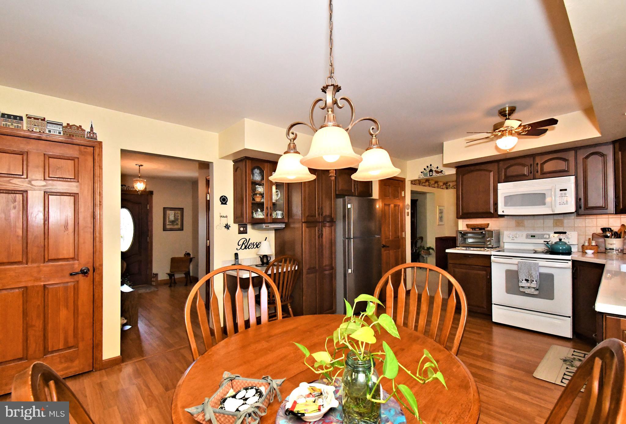 700 Alexander Drive Hatfield, PA 19440 - Photo 22 of 57 a kitchen with stainless steel appliances granite countertop a stove a sink dishwasher a dining table and chairs with wooden floor