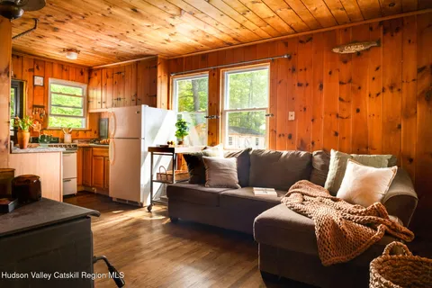 a living room with furniture a large window and a wooden floor