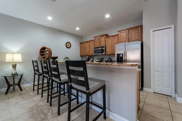 a kitchen with kitchen island a dining table chairs stainless steel appliances and cabinets