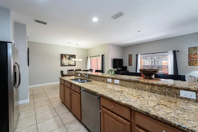 a large kitchen with granite countertop a large counter top stainless steel appliances and cabinets