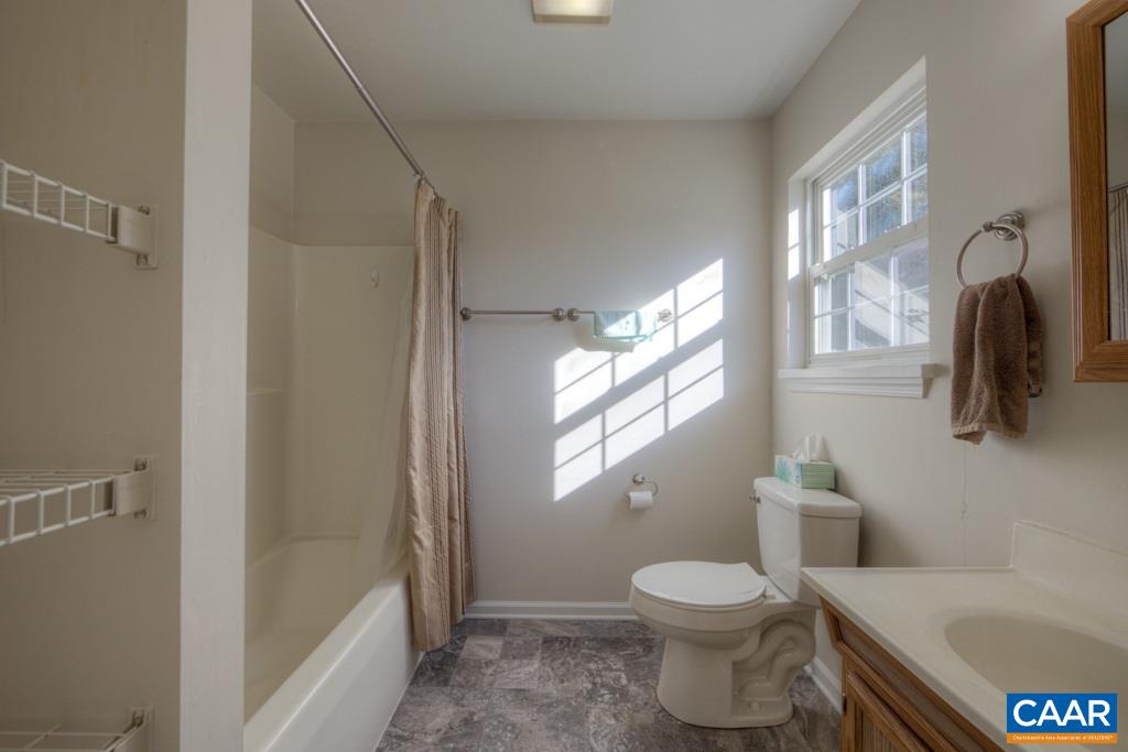 296 Morning Glory Road Ruckersville, VA 22968 - Photo 18 of 27 a bathroom with a granite countertop toilet a sink and a bathtub
