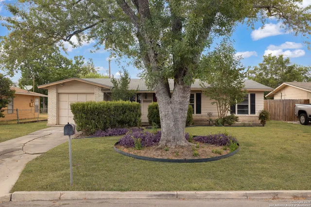 a front view of house with a garden and trees