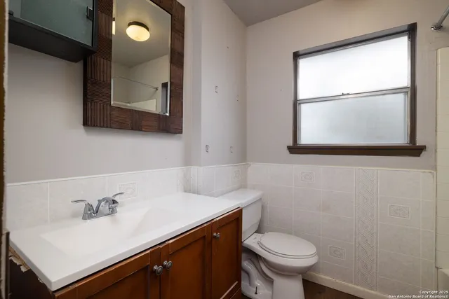 a bathroom with a sink toilet and mirror