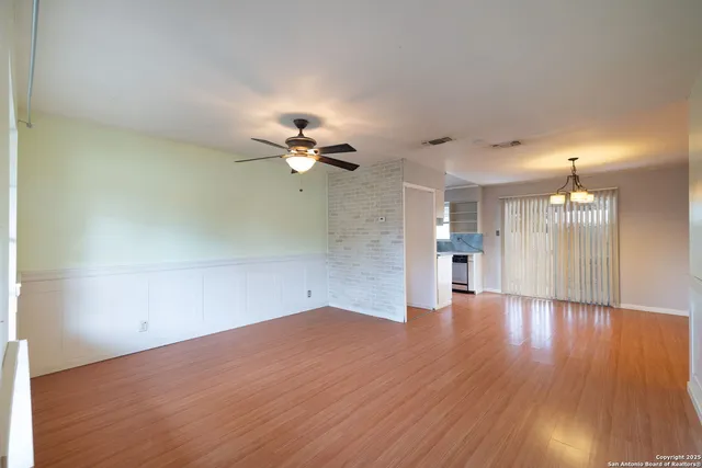 a view of empty room with wooden floor