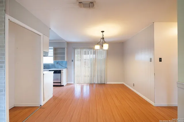 a view of empty room with wooden floor and window