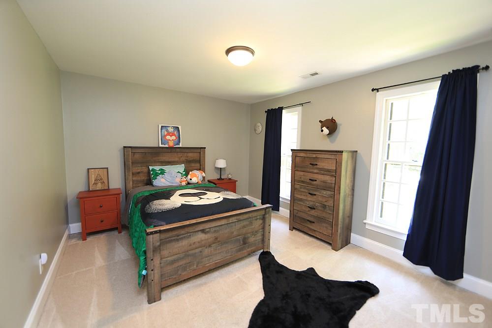 716 Bennington Drive Raleigh, NC 27615 - Photo 12 of 29 a bedroom with a bed and wooden floor