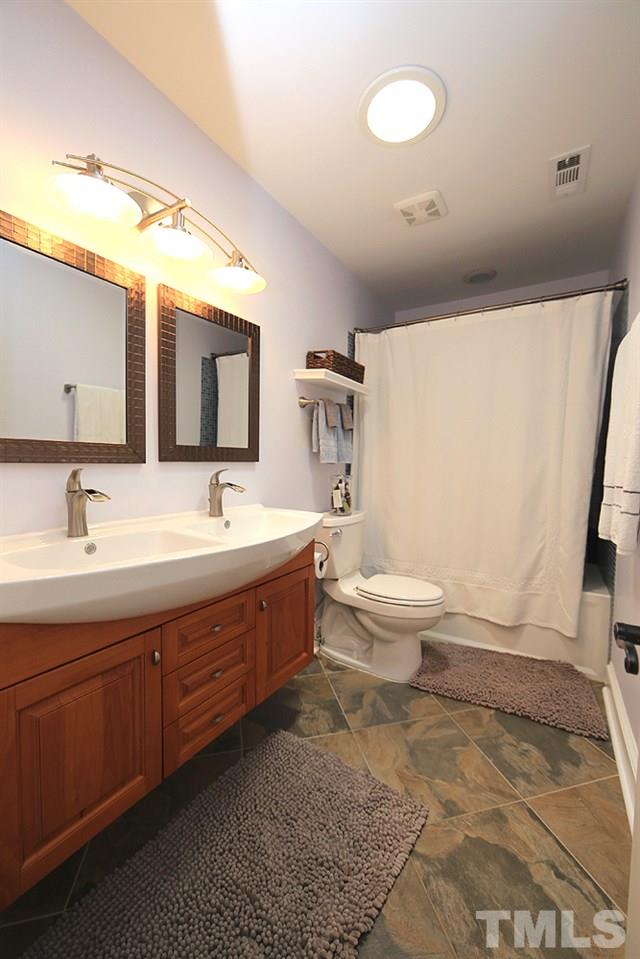716 Bennington Drive Raleigh, NC 27615 - Photo 14 of 29 a bathroom with a double vanity sink toilet and mirror