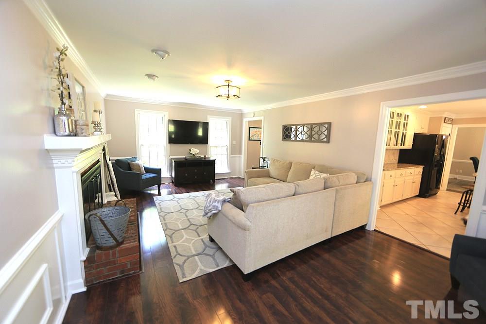 716 Bennington Drive Raleigh, NC 27615 - Photo 6 of 29 a living room with furniture a flat screen tv and a fireplace