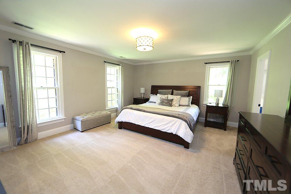 716 Bennington Drive Raleigh, NC 27615 - Photo 10 of 29 a bedroom with a large bed and a tv on dresser