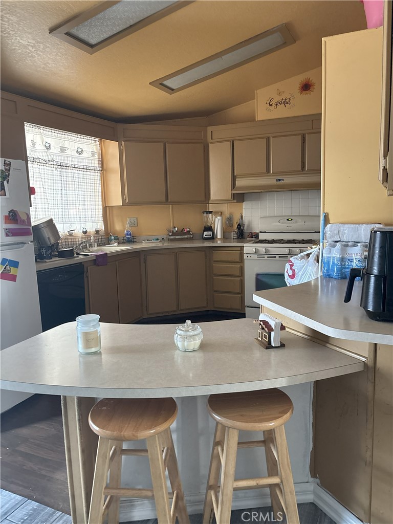 4080 Pedley Road, Unit 2 Jurupa Valley, CA 92509 - Photo 18 of 21 a kitchen with stainless steel appliances a table chairs sink and cabinets