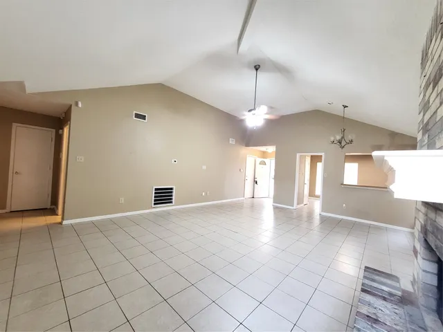 a view of a hallway with chandelier and fire place