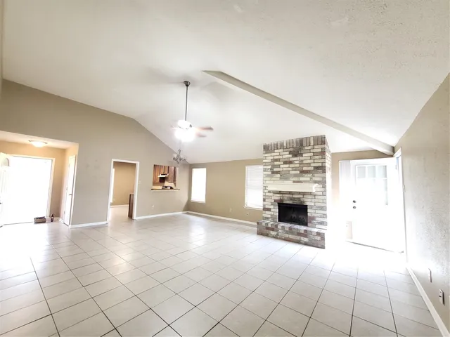 an empty room with fireplace and windows