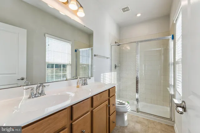 a bathroom with a granite countertop sink toilet a large mirror and shower