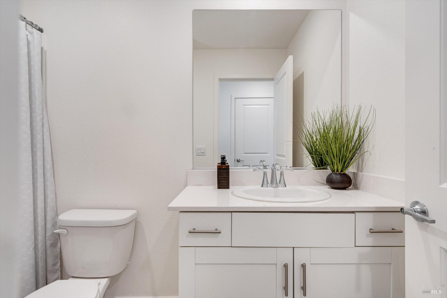 6054 Oxford Place Rohnert Park, CA 94928 - Photo 30 of 44 a bathroom with a toilet a sink and mirror