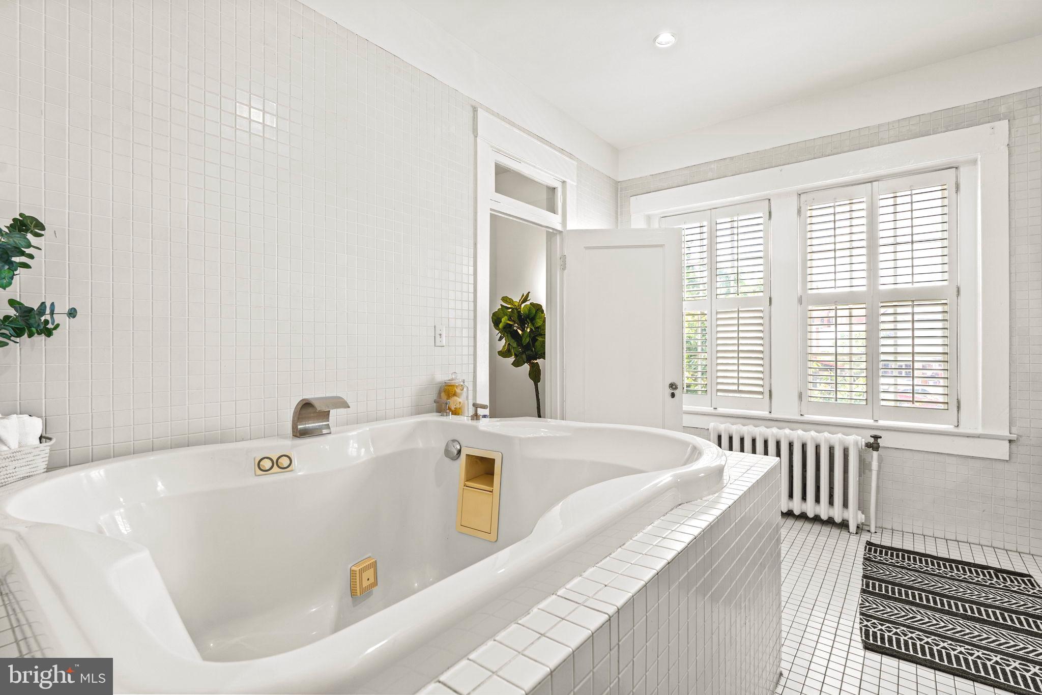 1736 Columbia Road Northwest, Unit 102 Washington, DC 20009 - Photo 19 of 39 a bath tub sitting in a bathroom next to a window