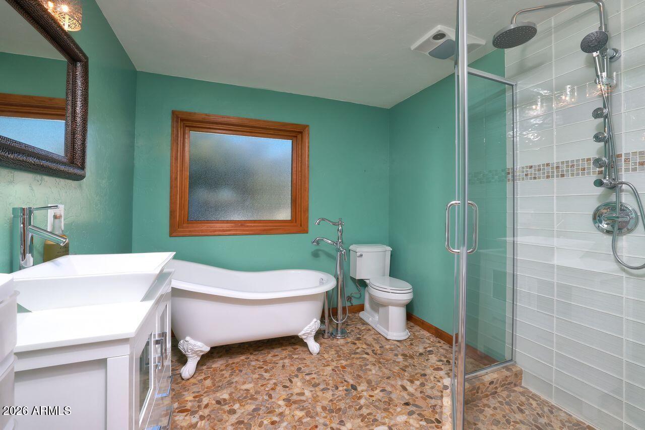 8741 East Woodland Road Tucson, AZ 85749 - Photo 25 of 51 a bathroom with a toilet sink and mirror