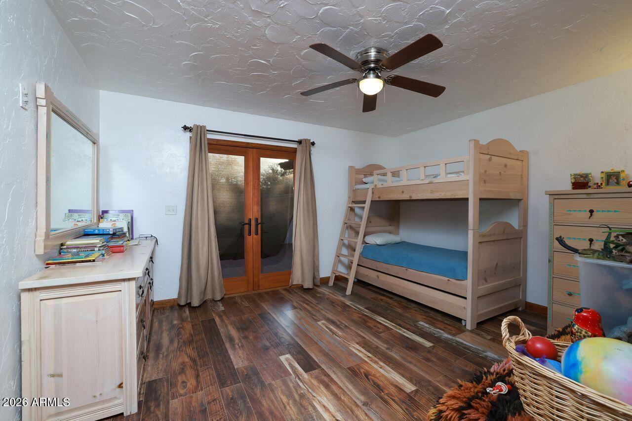 8741 East Woodland Road Tucson, AZ 85749 - Photo 27 of 51 a bedroom with a bed and a chandelier