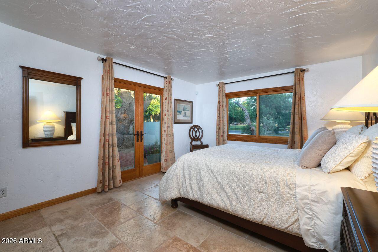 8741 East Woodland Road Tucson, AZ 85749 - Photo 29 of 51 a bedroom with a bed and a large window