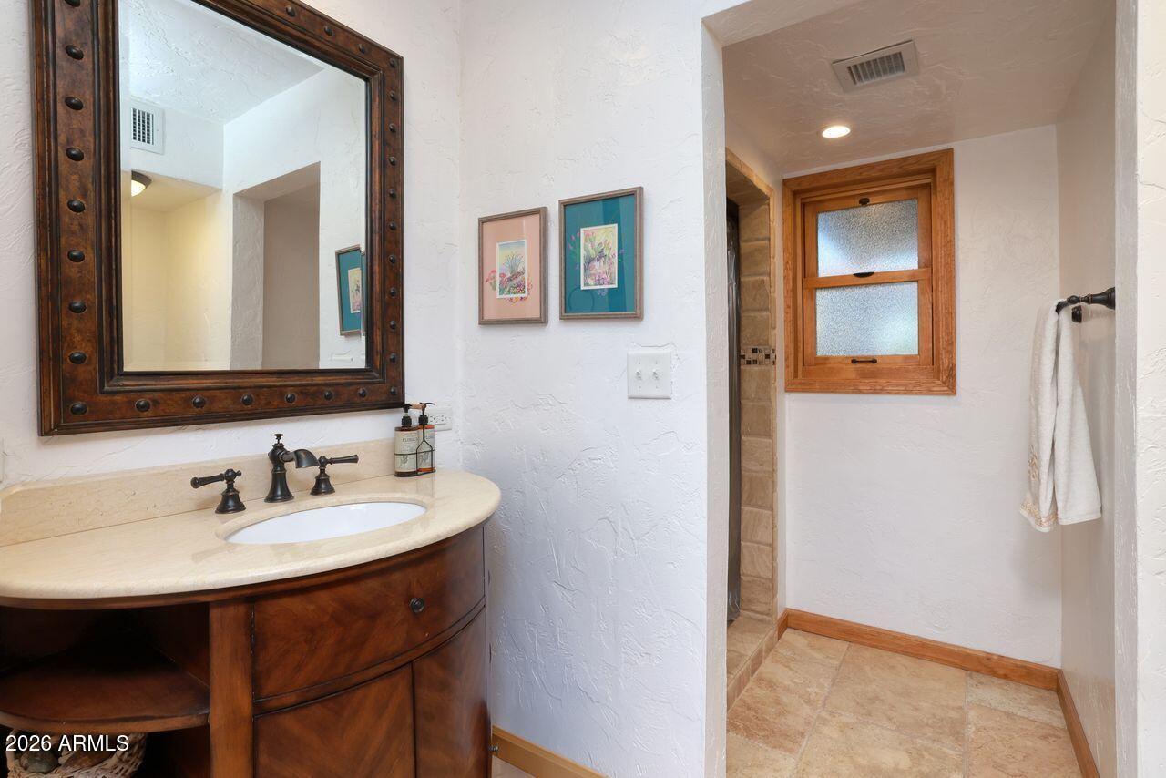 8741 East Woodland Road Tucson, AZ 85749 - Photo 30 of 51 a bathroom with a sink and a mirror