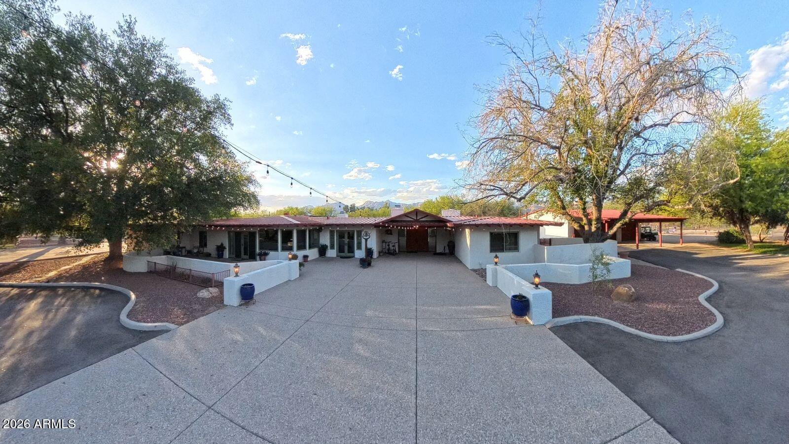8741 East Woodland Road Tucson, AZ 85749 - Photo 47 of 51 a view of a patio with table and chairs potted plants and large tree