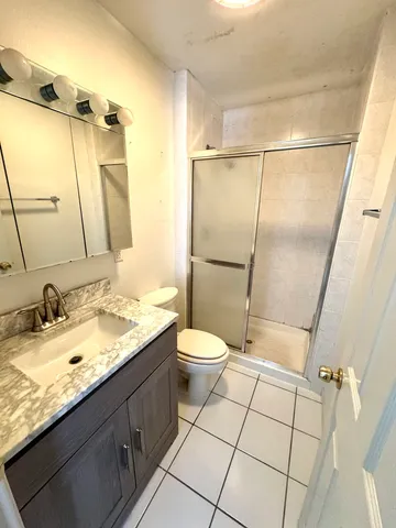 a bathroom with a granite countertop sink toilet and shower