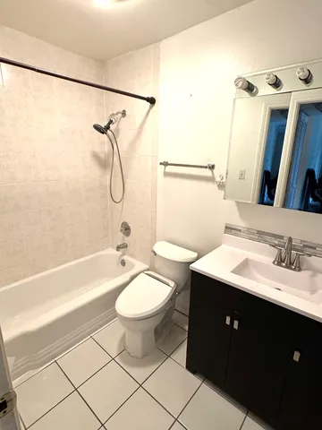a bathroom with a double vanity sink toilet mirror and shower