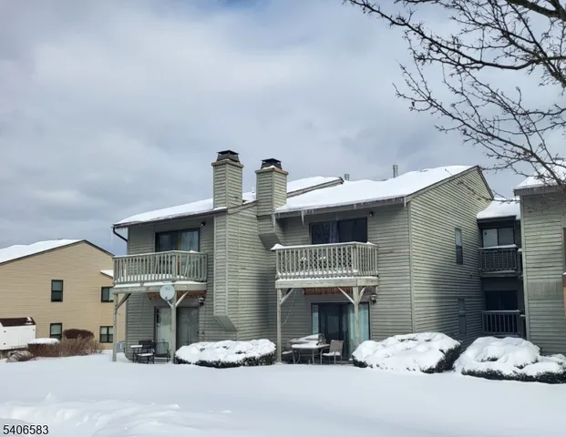 a view of a house with two chairs and a fireplace