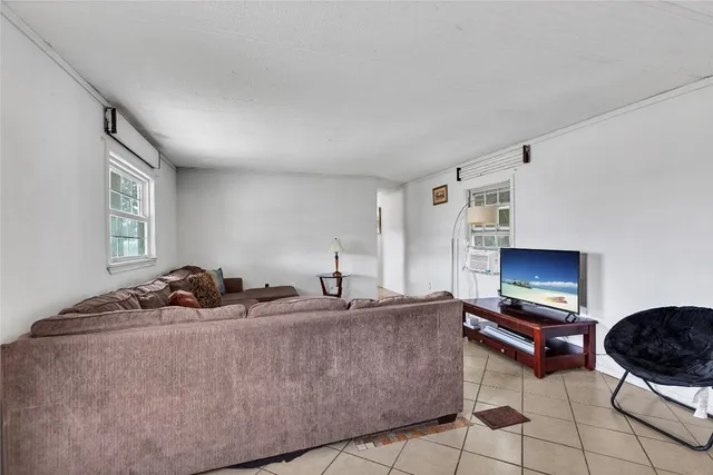 a living room with furniture a flat screen tv and a window