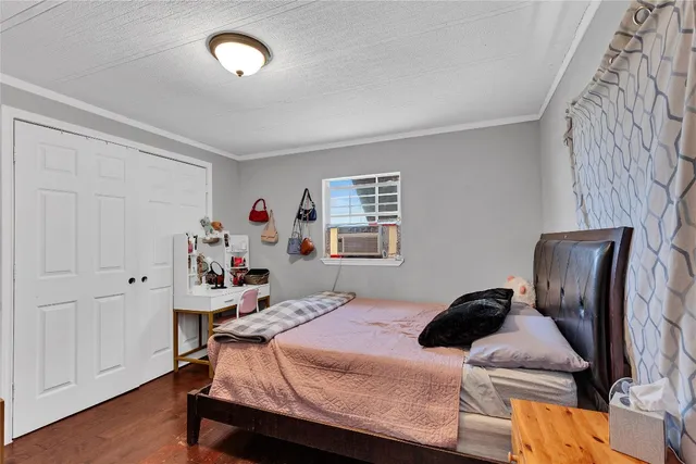a bedroom with a bed and wooden floor