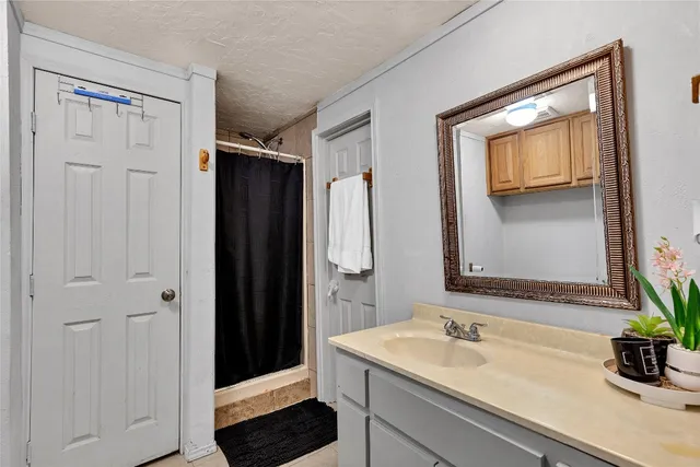 a bathroom with a sink a mirror and shower