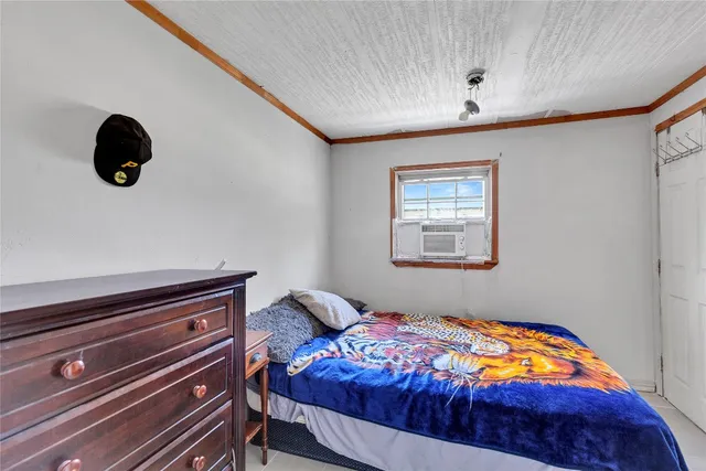 a bedroom with a bed and a lamp on the dresser
