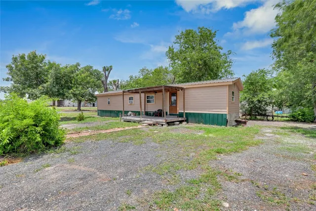 a view of a house with backyard and trees