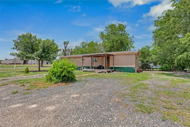 a view of a house with backyard and trees