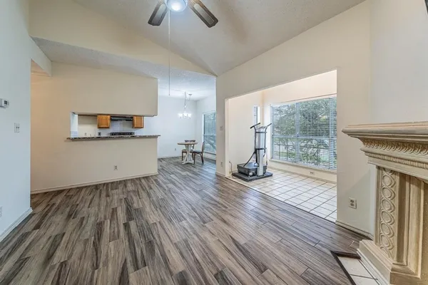 a view of an empty room with wooden floor and a fireplace