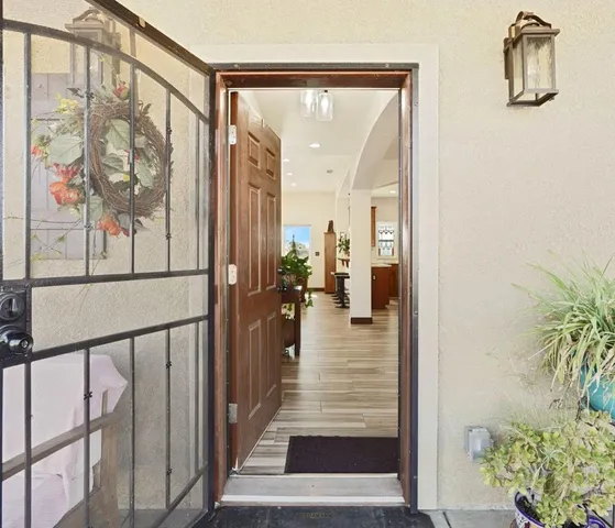 a view of a hallway with wooden floor and windows