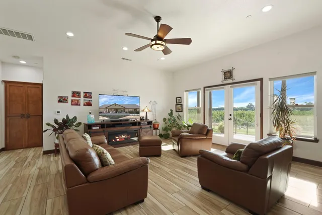 a living room with furniture floor to ceiling window and a flat screen tv