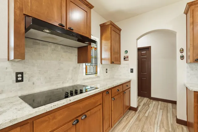 a kitchen with granite countertop a sink a stove and cabinets