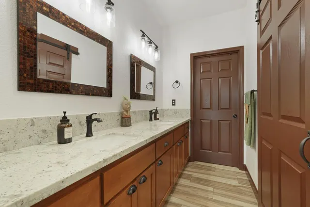 a bathroom with a sink double vanity granite and a mirror