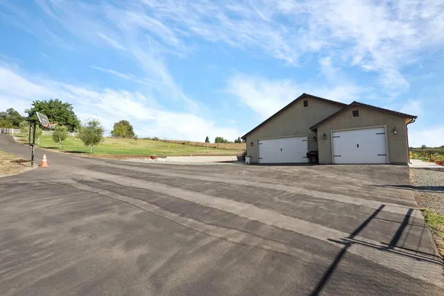a view of a house with a yard and potted plants