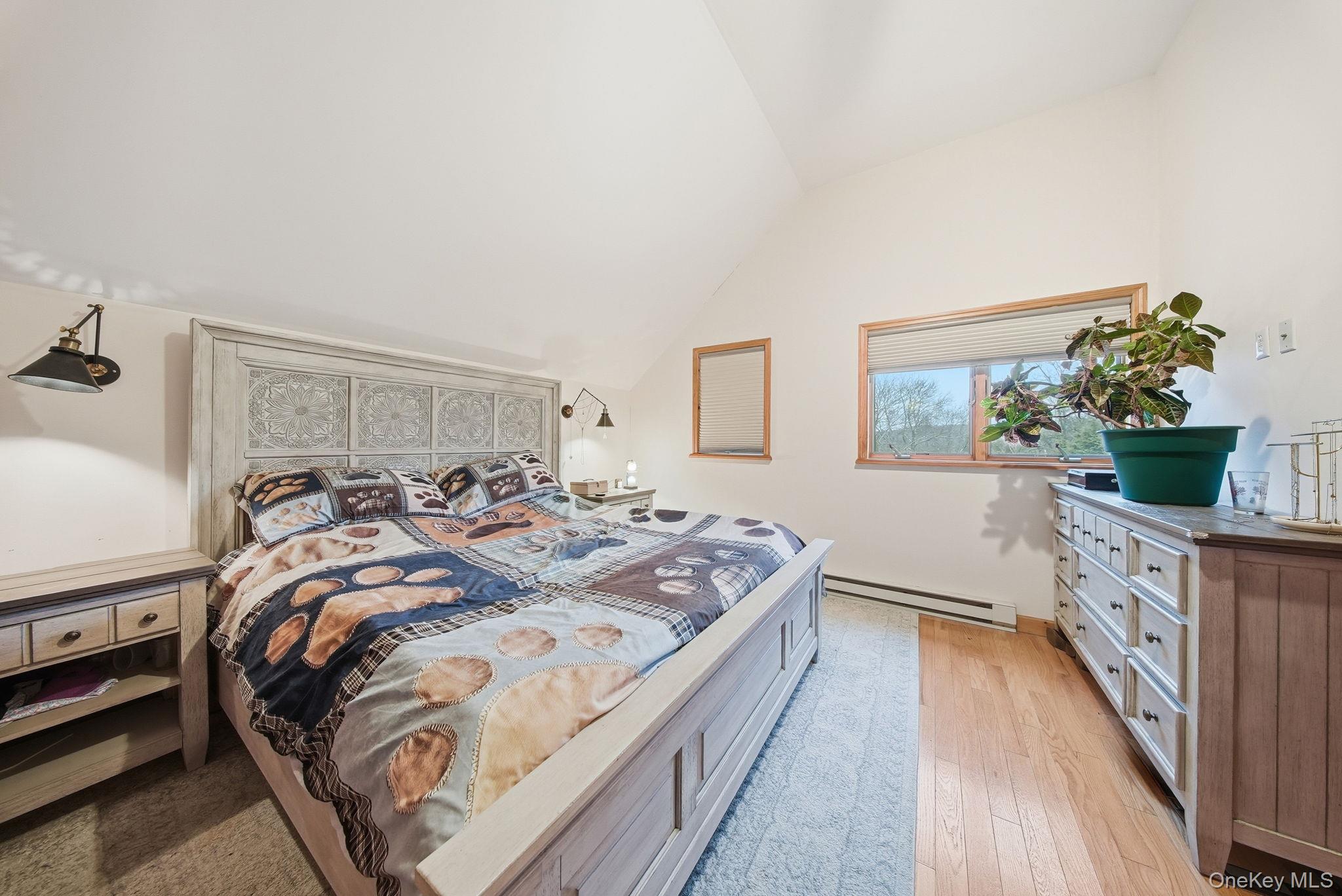 191 David Rhodes Road Wurtsboro, NY 12790 - Photo 21 of 39 a bed sitting in a bedroom next to a window with potted plant