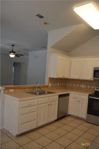 a view of hallway with chandelier fan