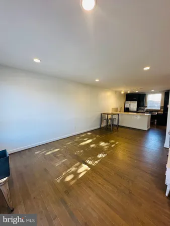 a view of room and kitchen with wooden floor