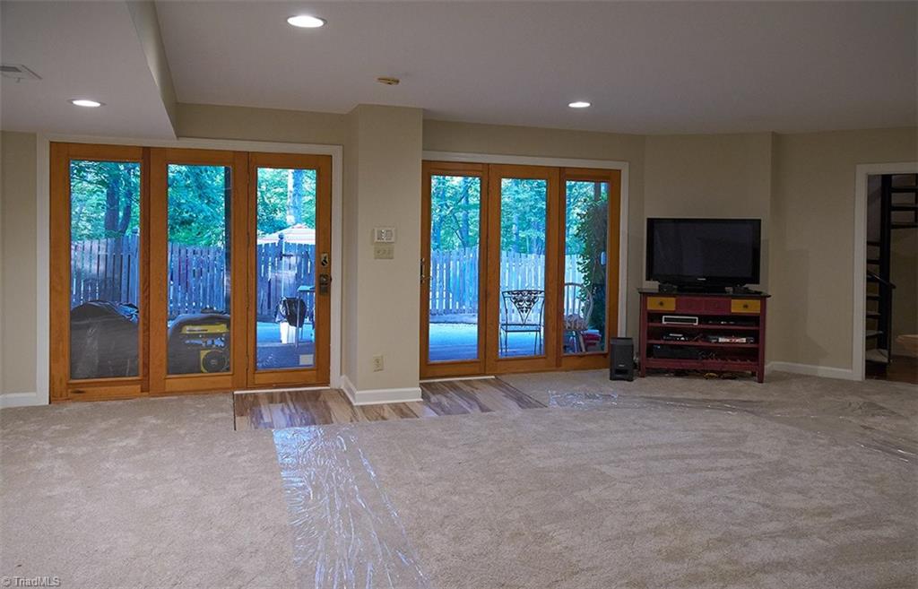5205 Rambling Road Greensboro, NC 27409 - Photo 25 of 30 Huge family room with new carpet in the finished basement. Doors lead to fenced pool and hot tub! There's plenty of room for a pool table in addition to all of your other furniture! Perfect space for entertaining!
