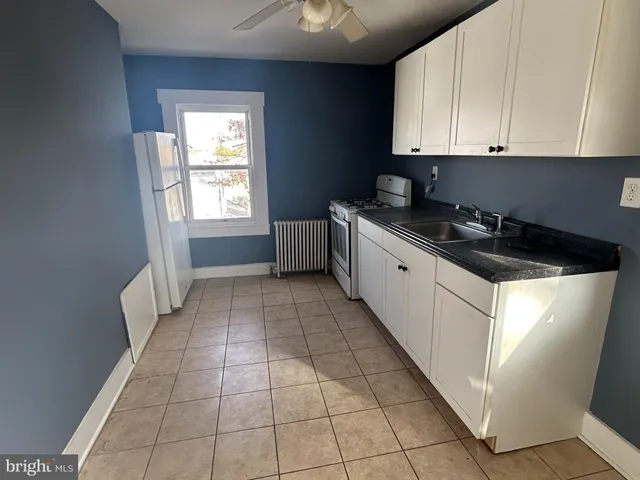 a kitchen with a sink a stove and cabinets