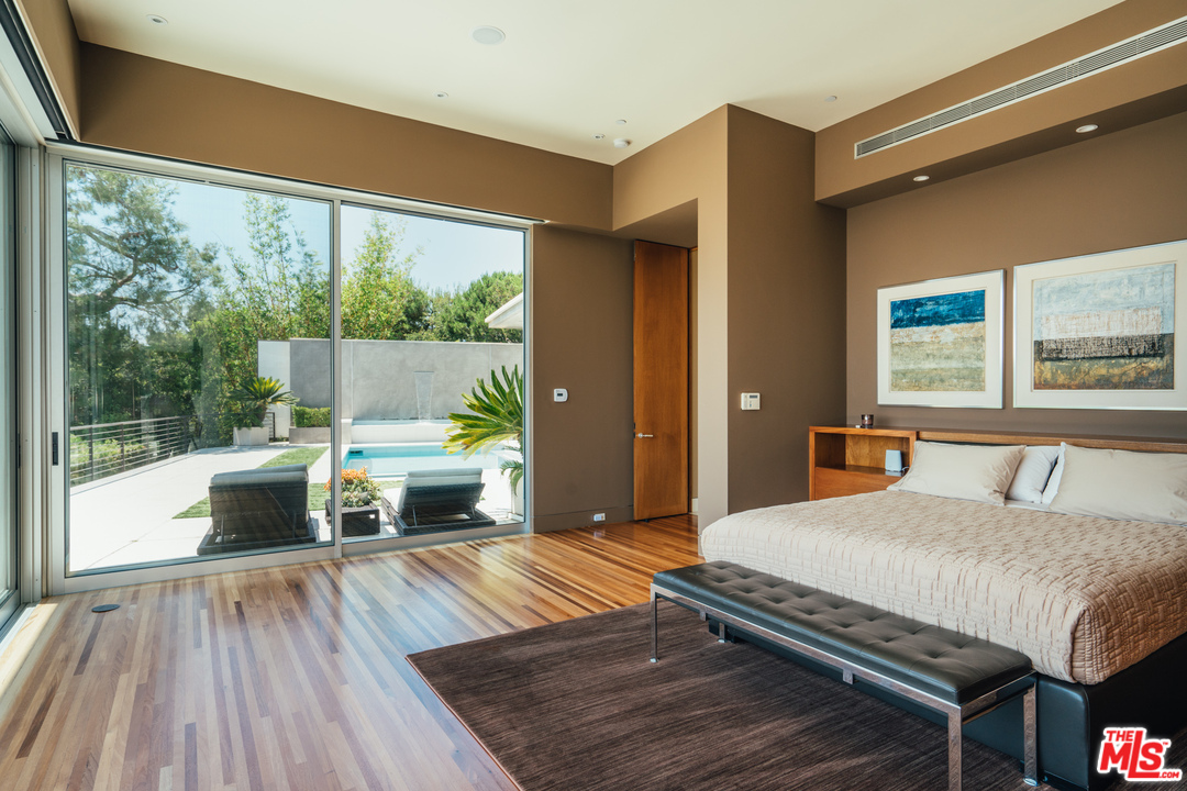 1470 Carla Ridge Beverly Hills, CA 90210 - Photo 15 of 44 a bedroom with a bed and a large window with balcony view