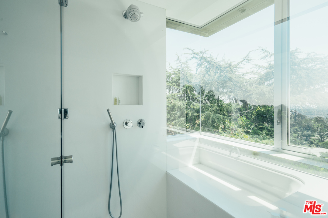 1470 Carla Ridge Beverly Hills, CA 90210 - Photo 19 of 44 a bathroom with a shower and a window