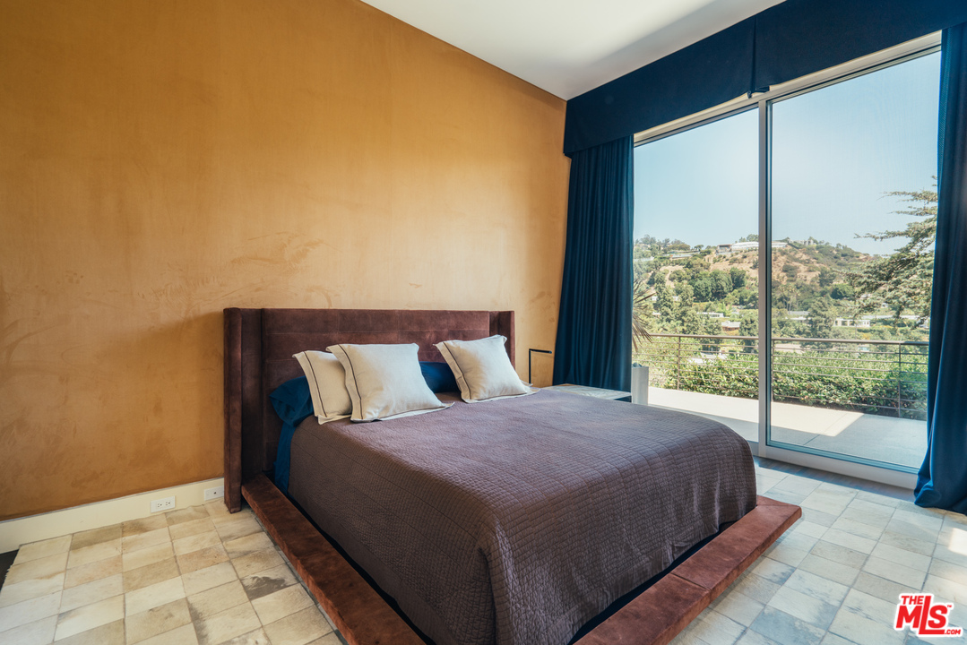 1470 Carla Ridge Beverly Hills, CA 90210 - Photo 21 of 44 a bedroom with a large bed and a large window