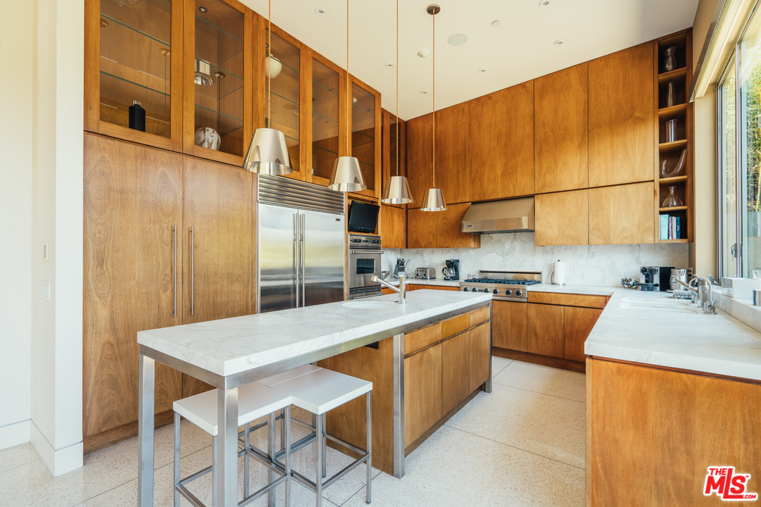 1470 Carla Ridge Beverly Hills, CA 90210 - Photo 24 of 44 a kitchen with stainless steel appliances granite countertop a sink and cabinets
