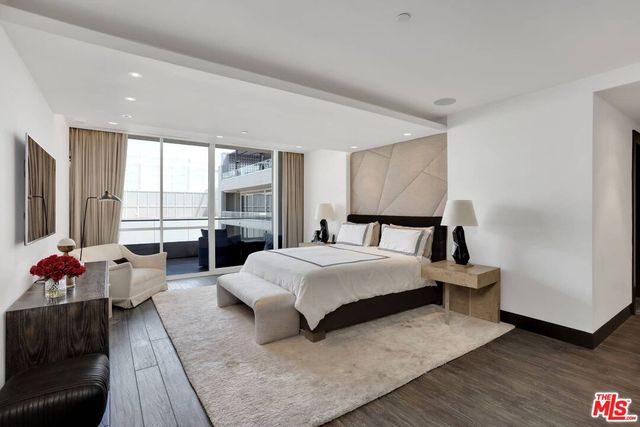 a spacious bedroom with a bed and glass window