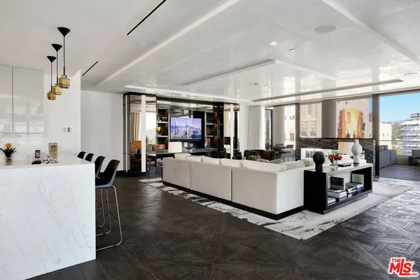 a large white kitchen with lots of counter space and chandelier